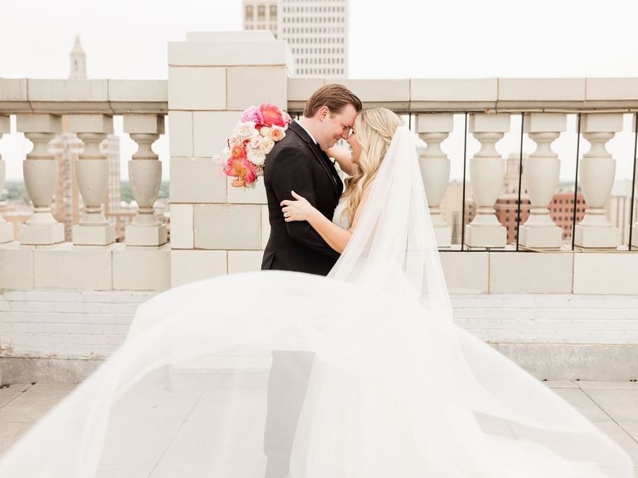 Bride and groom posing on the rooftop at The Mayo Hotel