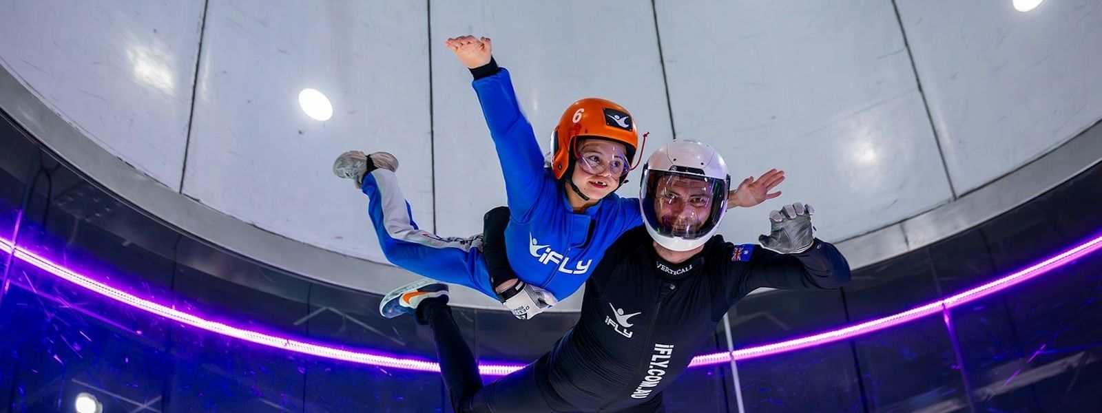 Two people skydiving inside an iFLY Downunder wind tunnel.