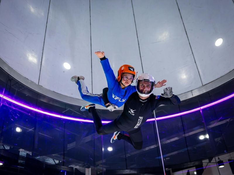 Two people skydiving inside an iFLY Downunder wind tunnel.