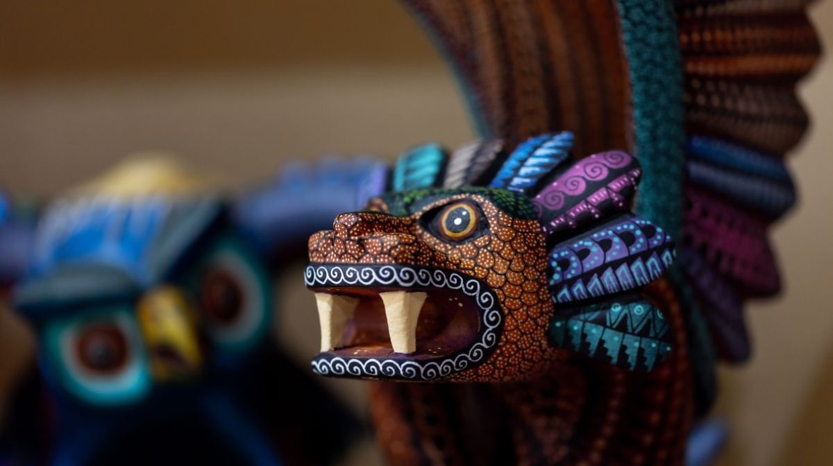 Close up of a colorful hand-carved dragon alebrije with intricate patterns near Camino Real Pedregal Mexico