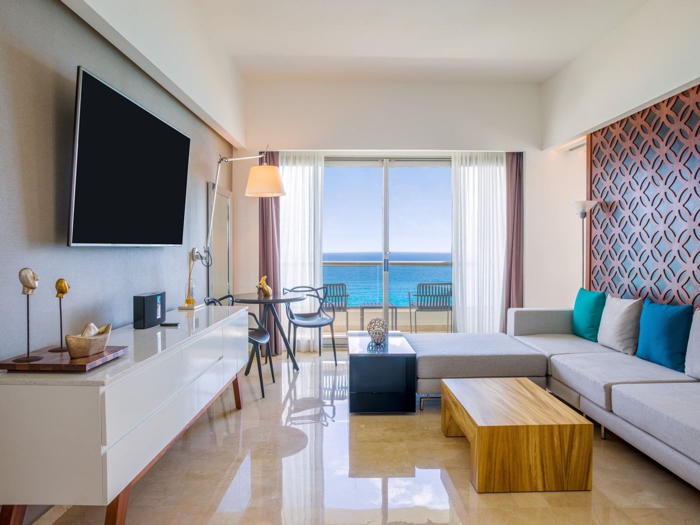 Fuego Suite's living room area with TV and sea view at Live Aqua Beach Resort Cancun