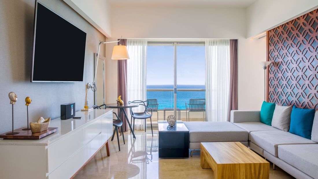 Fuego Suite's living room area with TV and sea view at Live Aqua Beach Resort Cancun