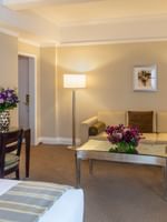 Cream sofa & table, and fresh purple floral bouquet with work desk in Premier City View with Terrace at Warwick New York