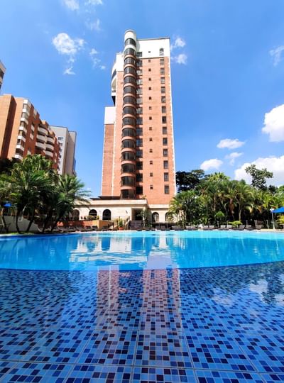 Vista exterior y skyline de ángulo bajo del Hotel Dann Carlton Medellín con piscina al aire libre