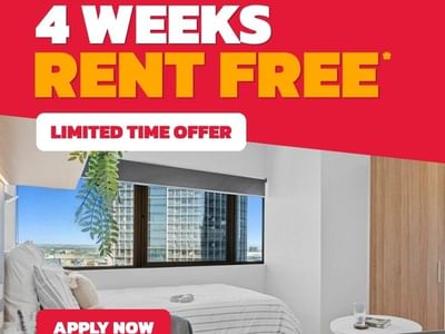 Modern student bedroom with white bed, city view window, and promotional offer for up to 4 weeks rent free at UniLodge Brisbane City