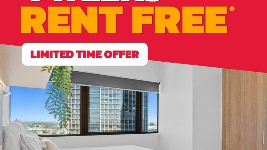 Modern student bedroom with white bed, city view window, and promotional offer for up to 4 weeks rent free at UniLodge Brisbane City