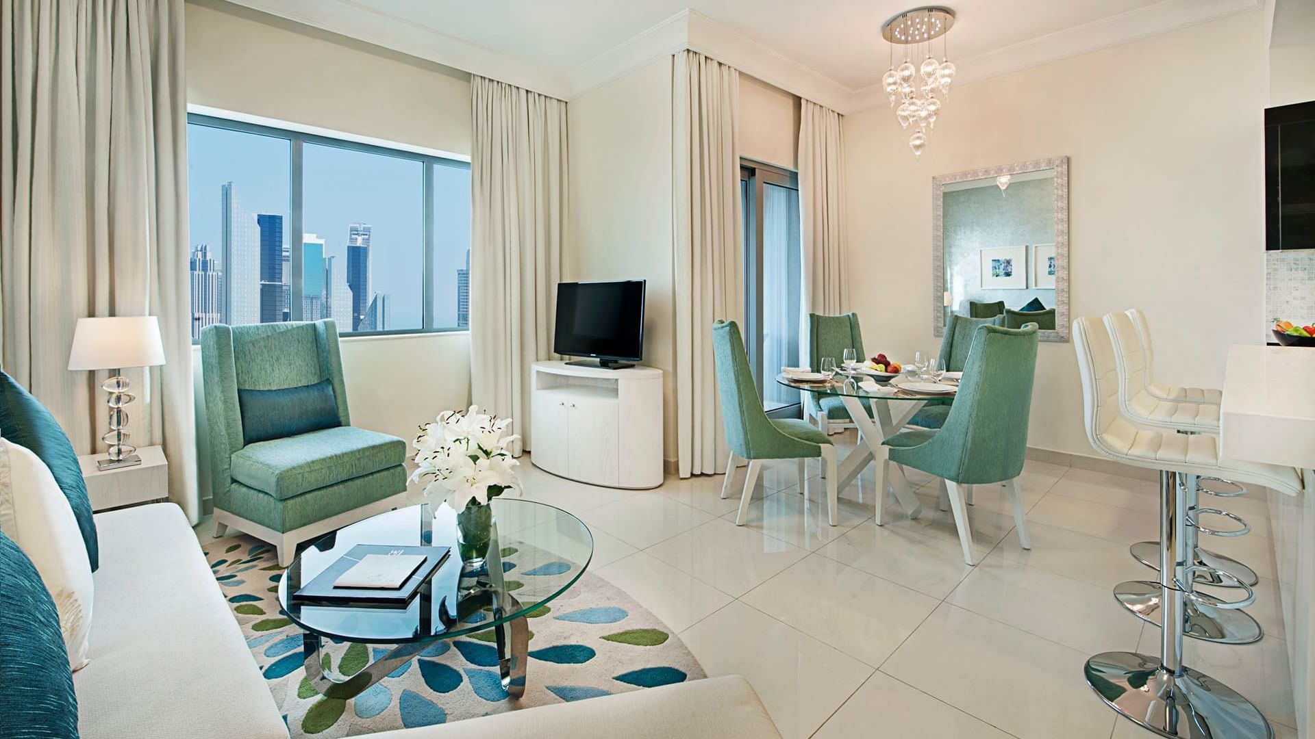 Lounge area with TV and dining table in Two Bedroom Suite at DAMAC Maison Dubai Mall Street