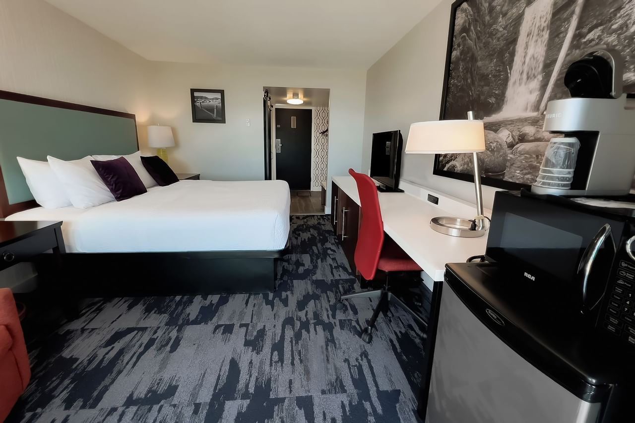 Guest room with two king beds, large desk, tv, microwave, fridge, chair