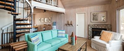 Livingroom area with a fireplace & spiral stairway at Catalina Island Company