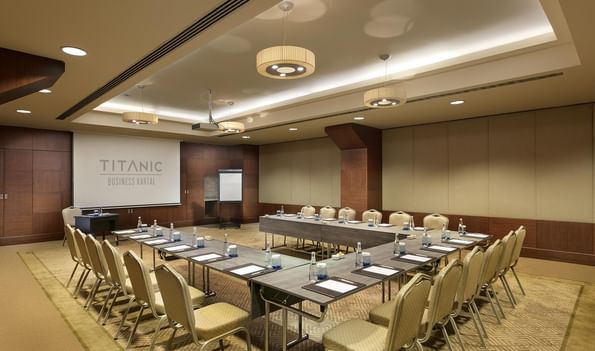 Titanic Business Kartal'daki Azor 3 toplantı salonunda, sandalyelerle çevrelenmiş U düzeninde toplantı masası bulunmaktadır.