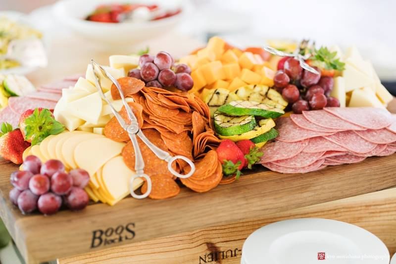 Wooden charcuterie board with assorted meats, cheeses, grapes, and crackers at Aramark Chauncey Conference Center