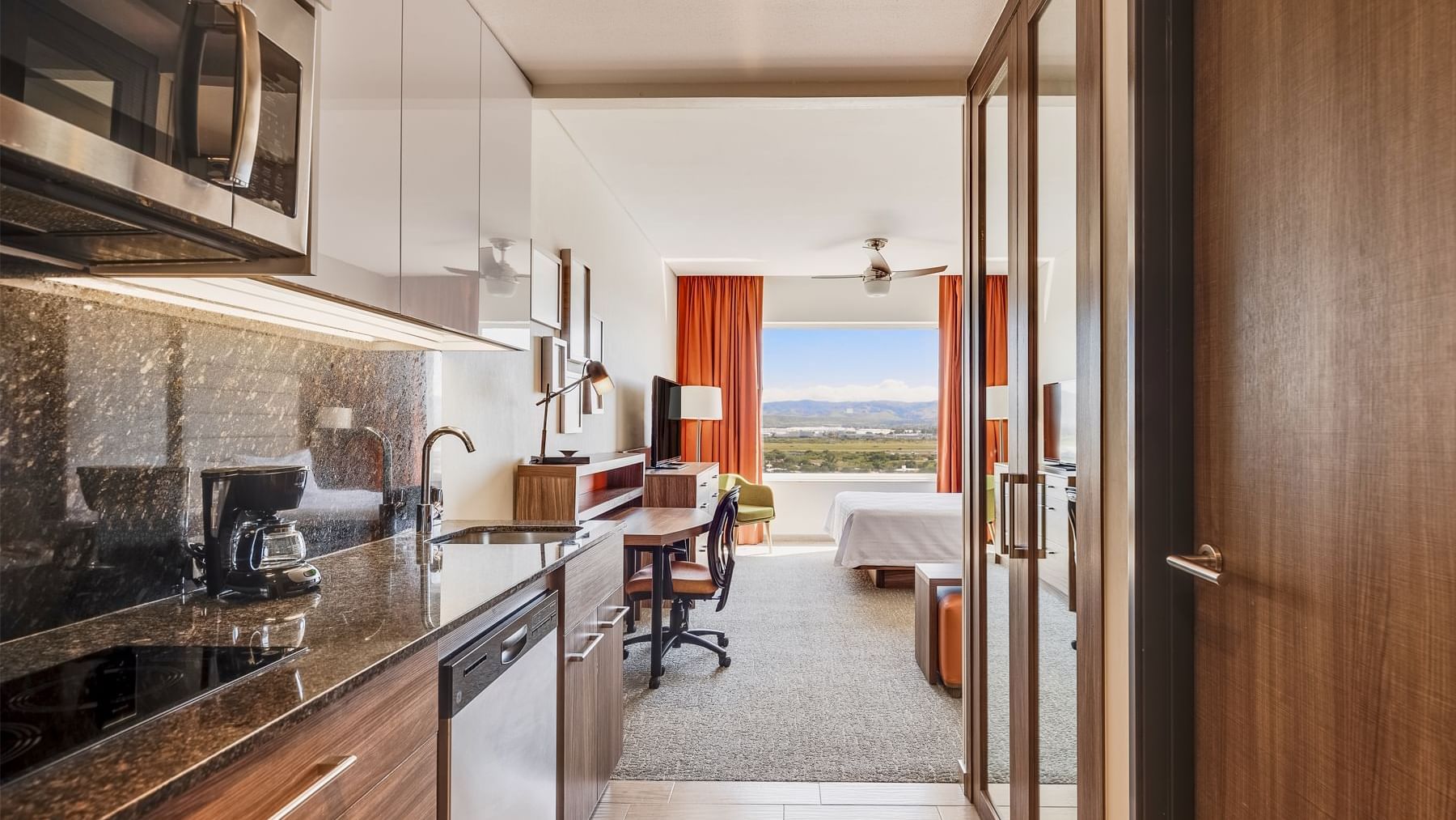 Modern Kitchen area and a work desk in Suite Queen at Fiesta Inn Suites Aeropuerto del Bajío Silao