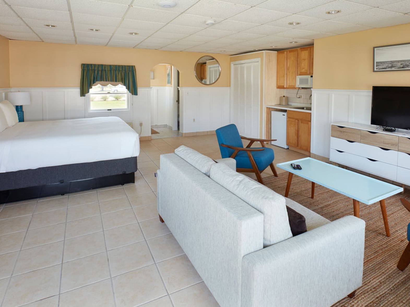 TV lounge by the bed and tiled floors in Poolhouse Studio at Breezeway Boutique Hotel