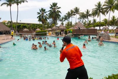 A man conducting an event in a pool at Fiesta Resort