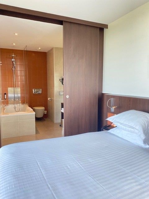 Chambre d'hôtel avec lit, salle de bain attenante et baignoire.