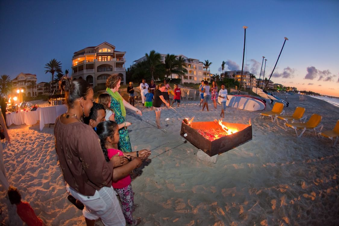 People by the bonfire on the beach at The Somerset on Grace Bay