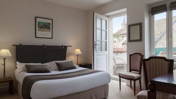 Bed & furniture in a room at Hotel de la Paix