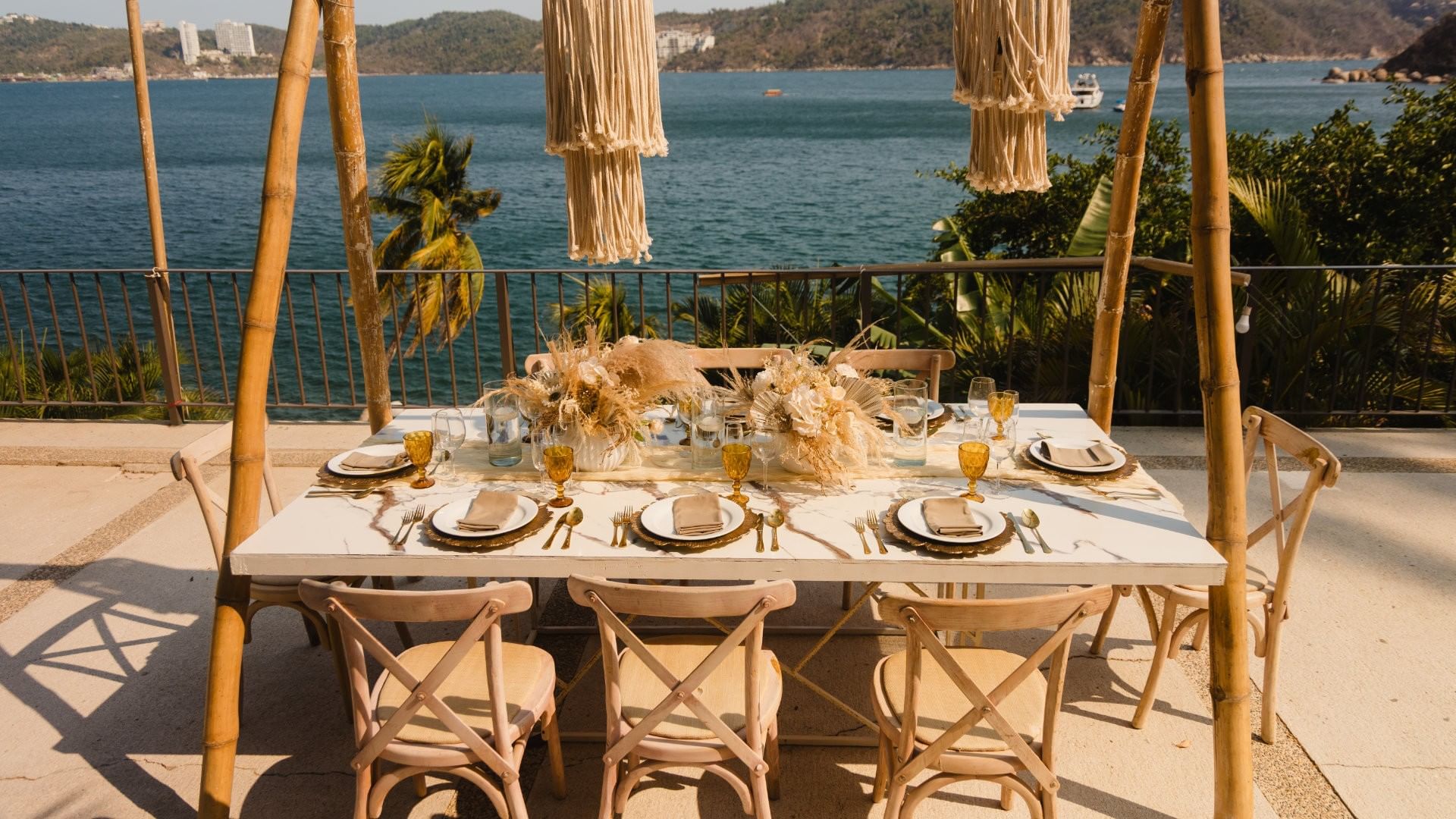 Camino Real III Scenic terrace event venue with marble tables overlooking a tropical bay at Camino Real Acapulco Diamante