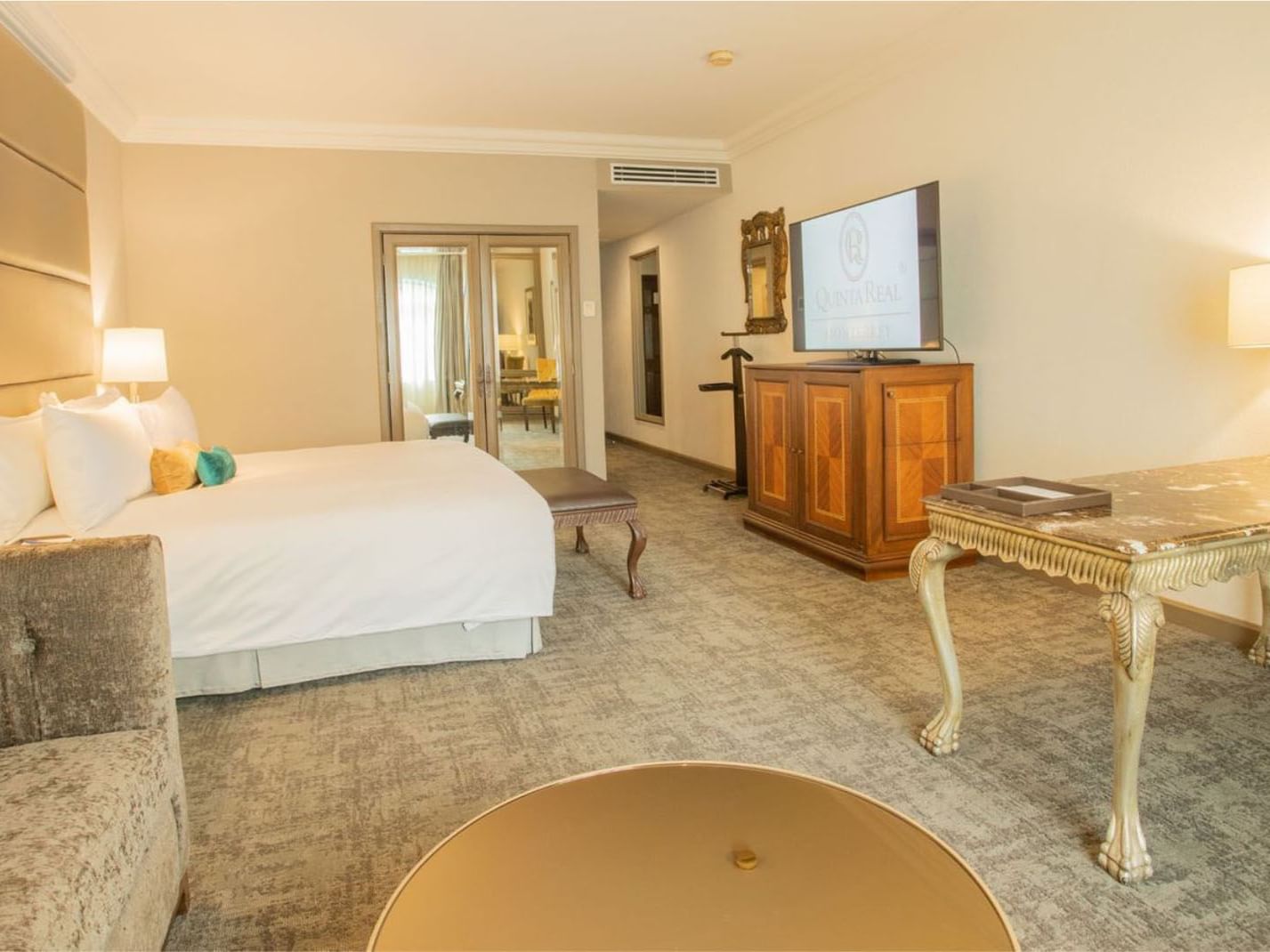 King Grand Class with a wooden armoire, mirrored doors, and a plush seating area at Quinta Real Monterrey