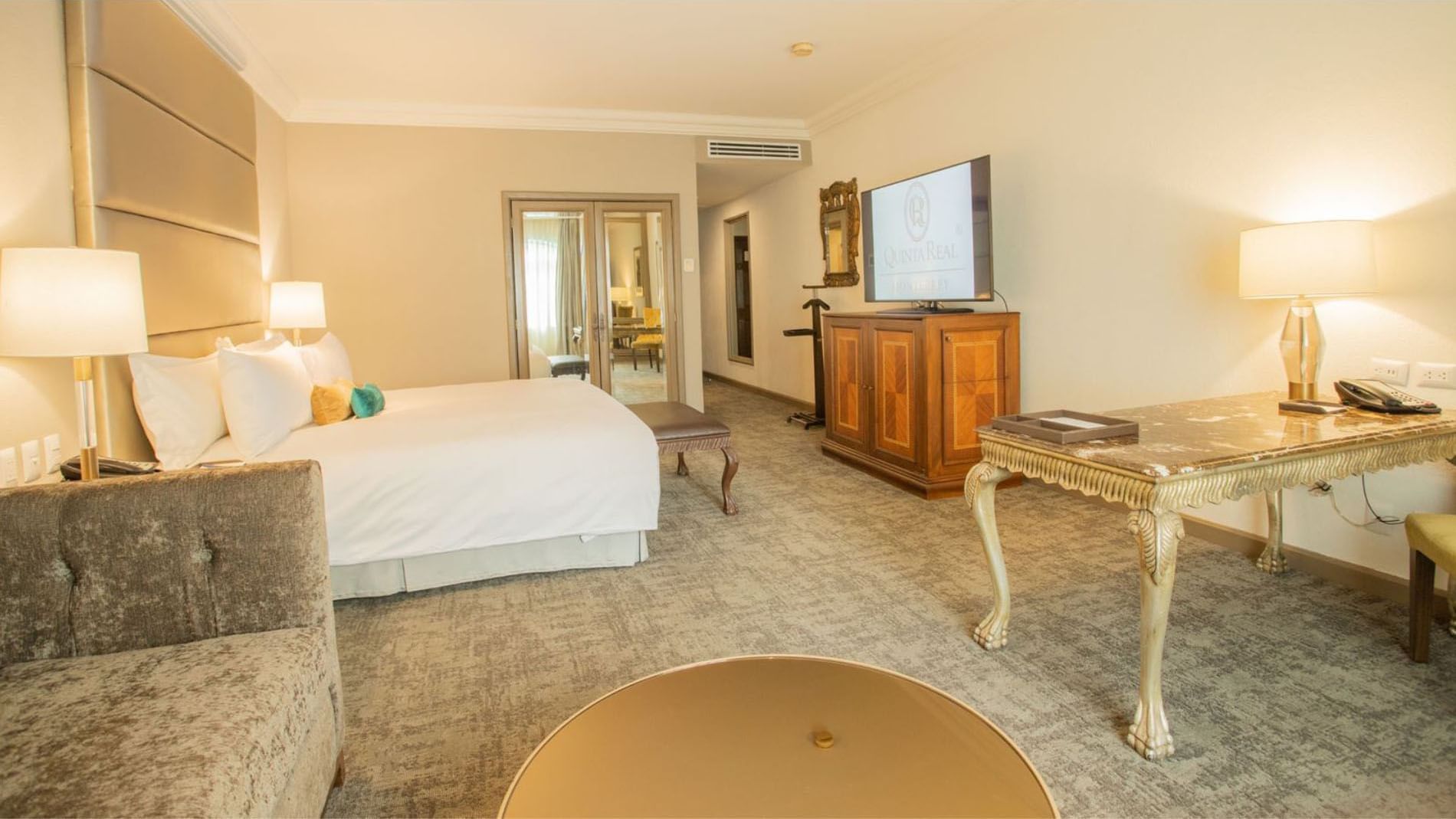 King Grand Class with a wooden armoire, mirrored doors, and a plush seating area at Quinta Real Monterrey