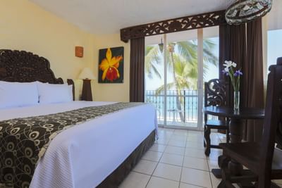 Room with bed, small table and sliding glass door