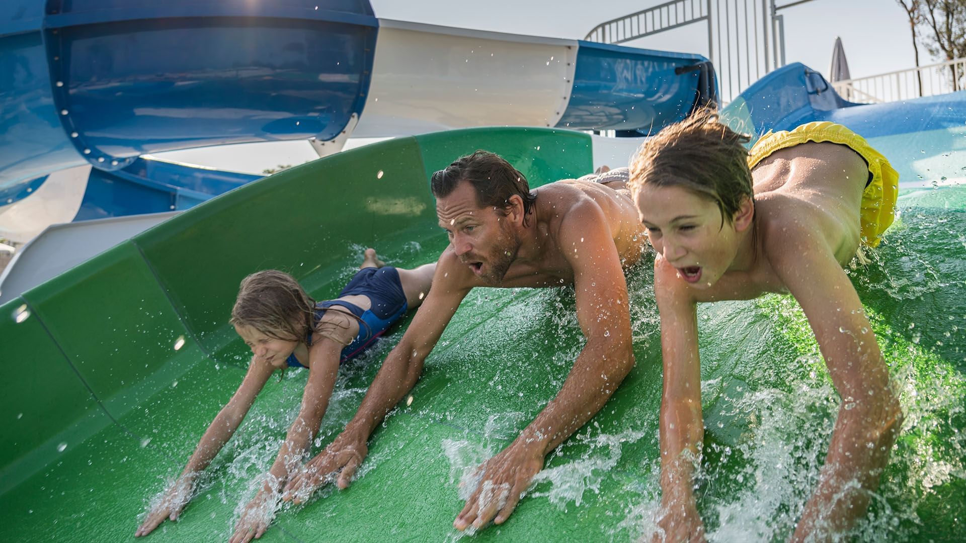 Father & 2 kids on a water slider at Falkensteiner Hotels
