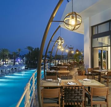 Beef Grill Club, Titanic Deluxe Lara’da havuz kenarında, akşam ışıklı açık hava restoranı.