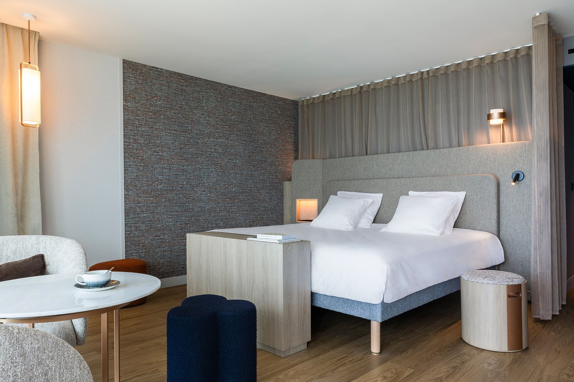 Intérieur et décoration d'un lit king-size avec fauteuils et table basse dans une chambre à l'Oceania Saint-Malo