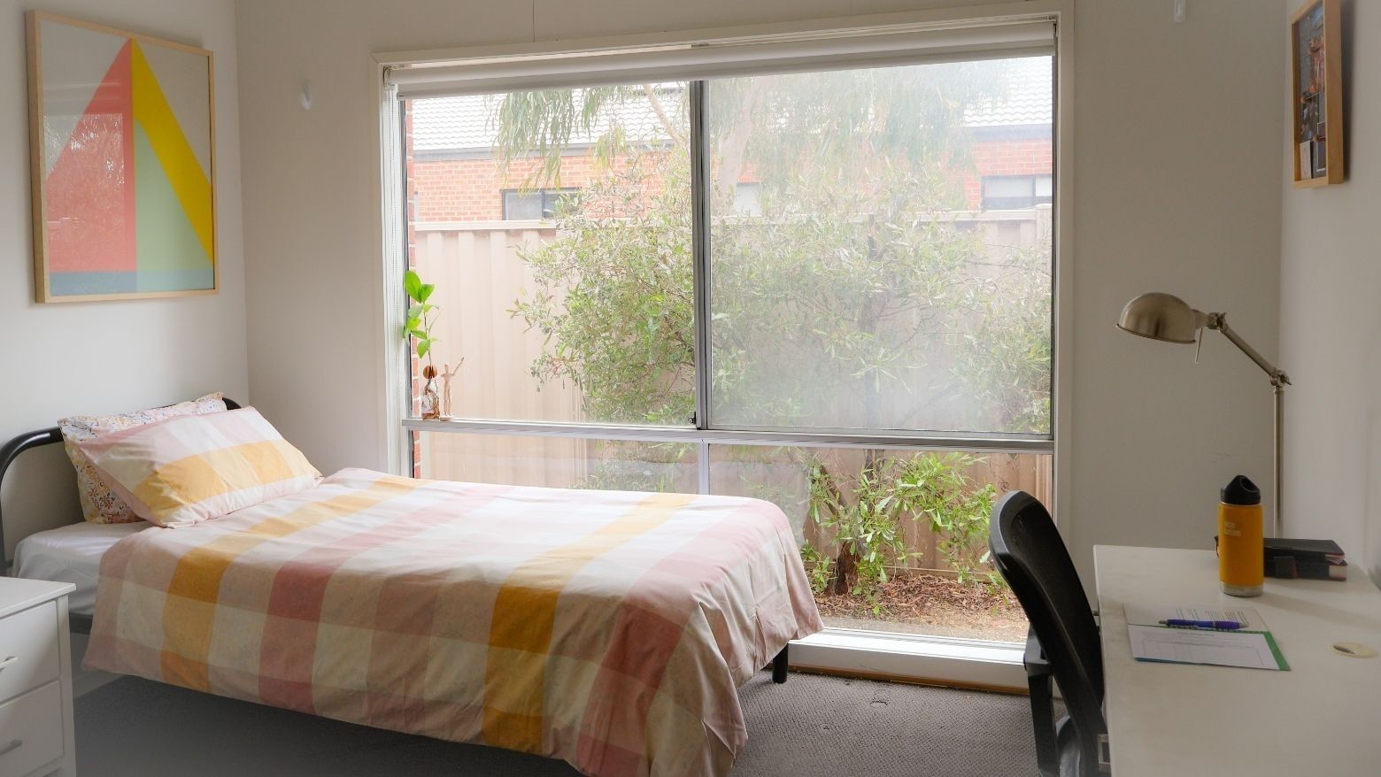A neat room with a bed, desk, and large window at La Trobe University Regional Housing - Ballarat.