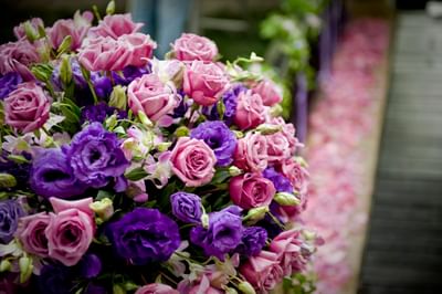 Vibrant bouquet of pink and purple roses set against a blurred floral pathway at The Saujana Hotel Kuala Lumpur
