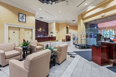 Lobby with seating, front desk, luggage carts, and indoor plants at Rosedale on Robson, one of the best hotels in Vancouver