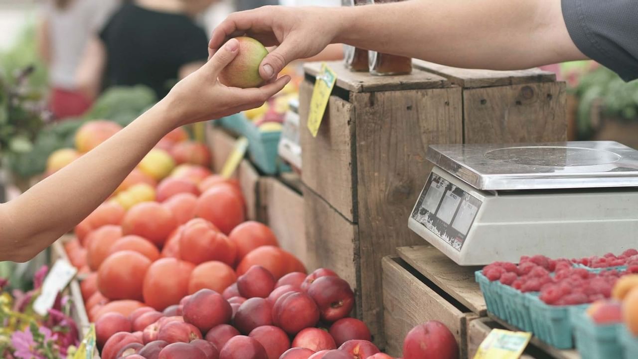 Hands grabbing fresh apple at farmer's market