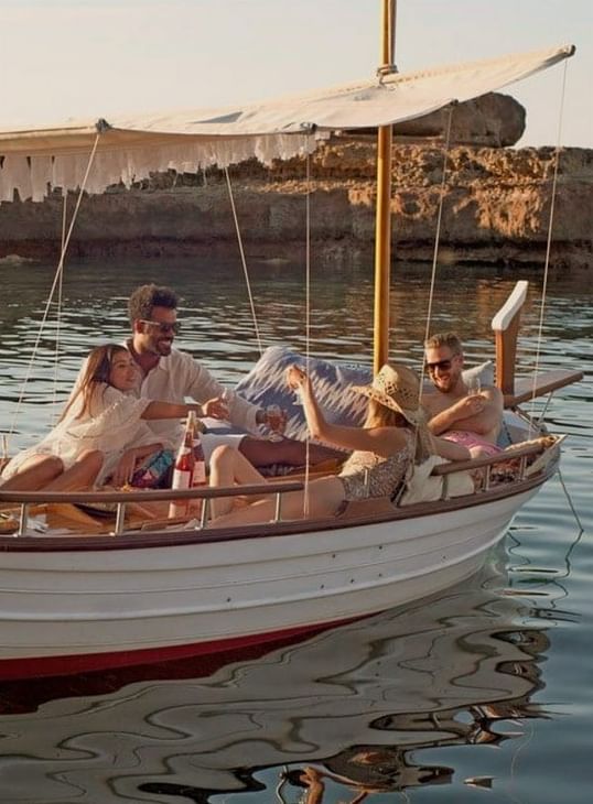 Groupe d'amis décontractés sur une barque flottante avec voile à Ibiza Gran Hotel