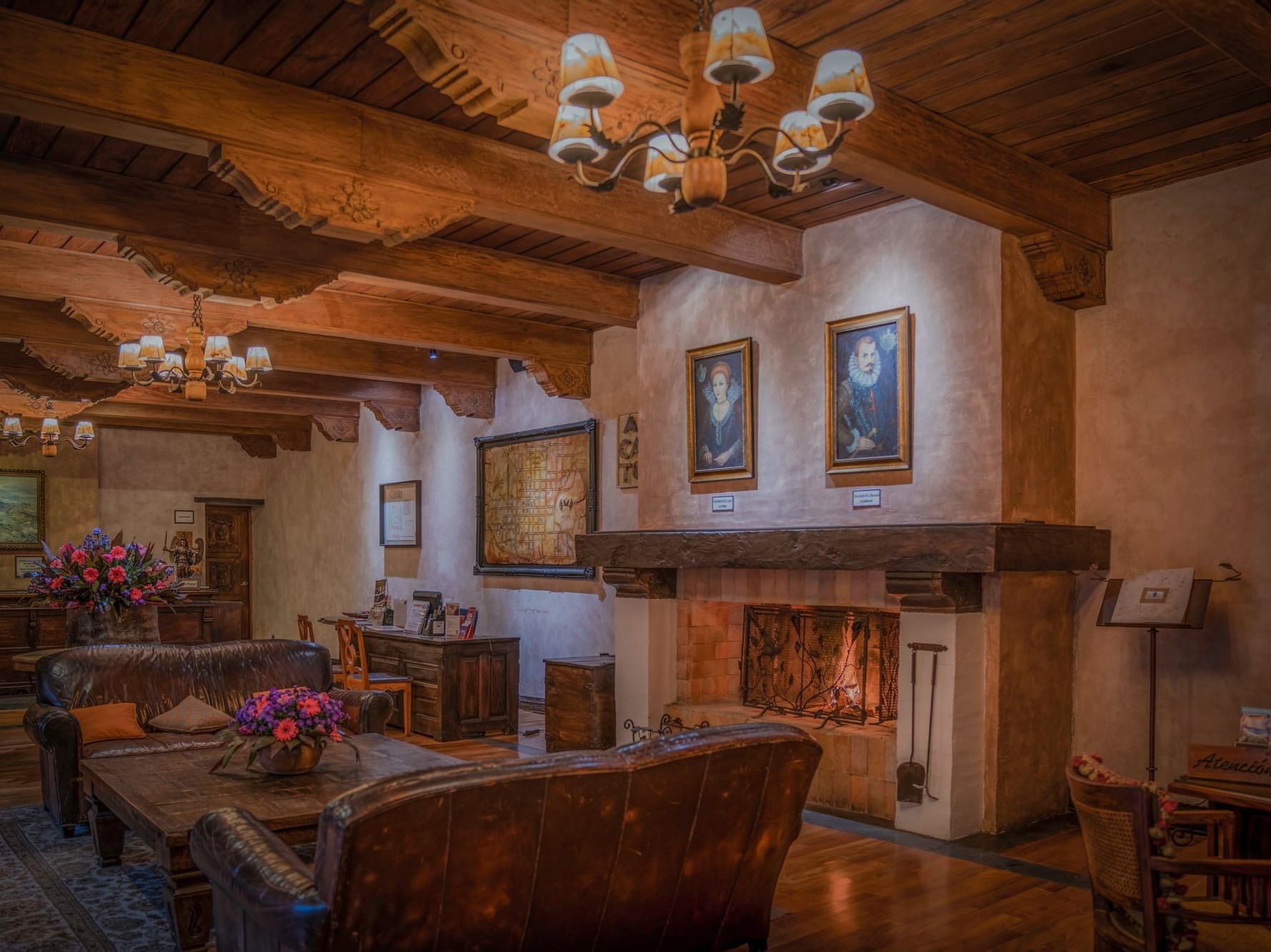 Fireplace by lobby lounge area with wall art at Porta Hotel Antigua