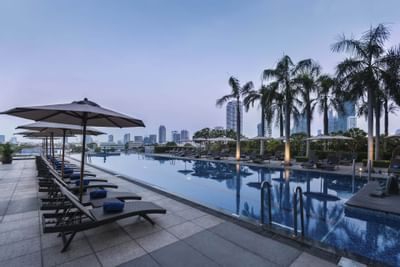 Sunbeds by the outdoor pool at Chatrium Hotel Bangkok