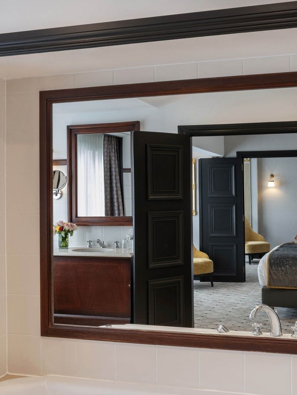 Elegante badkamerspiegel toont slaapkamer in Barsey Suite bij Hotel Barsey by Warwick, Brussel.