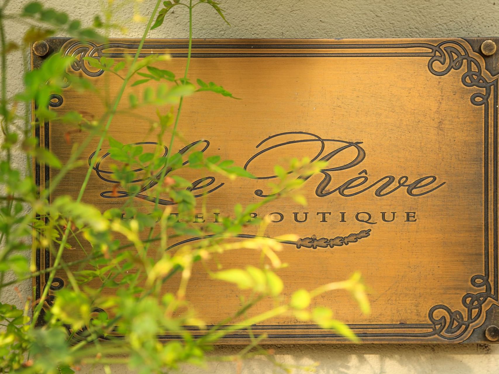 Close-up of Hotel Boutique Le Reve sign board on a wall