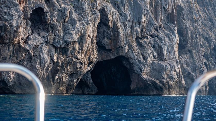 Majestätische Meereshöhle von Cova Blava mit kristallklarem türkisfarbenem Wasser, Sonnenlicht durch den Eingang
