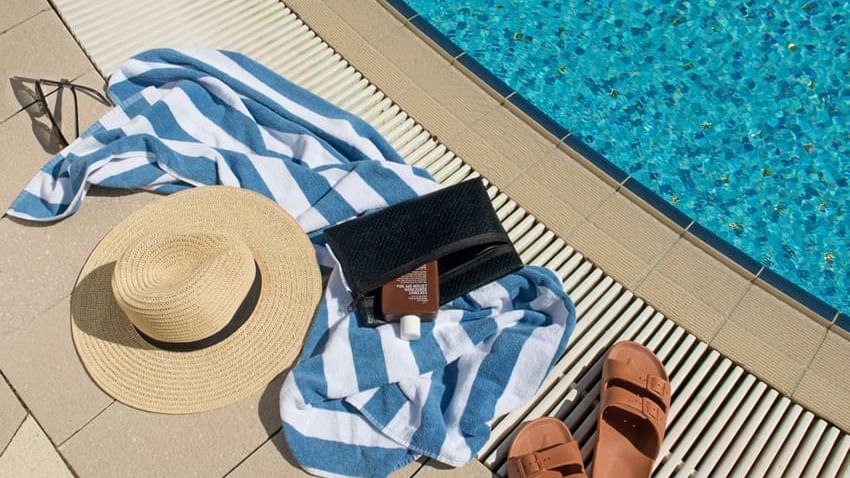 Close up on a hat & sandals by a pool at Crown Hotels