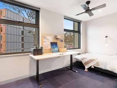 Clean student room with desk and bed at La Trobe University apartments.