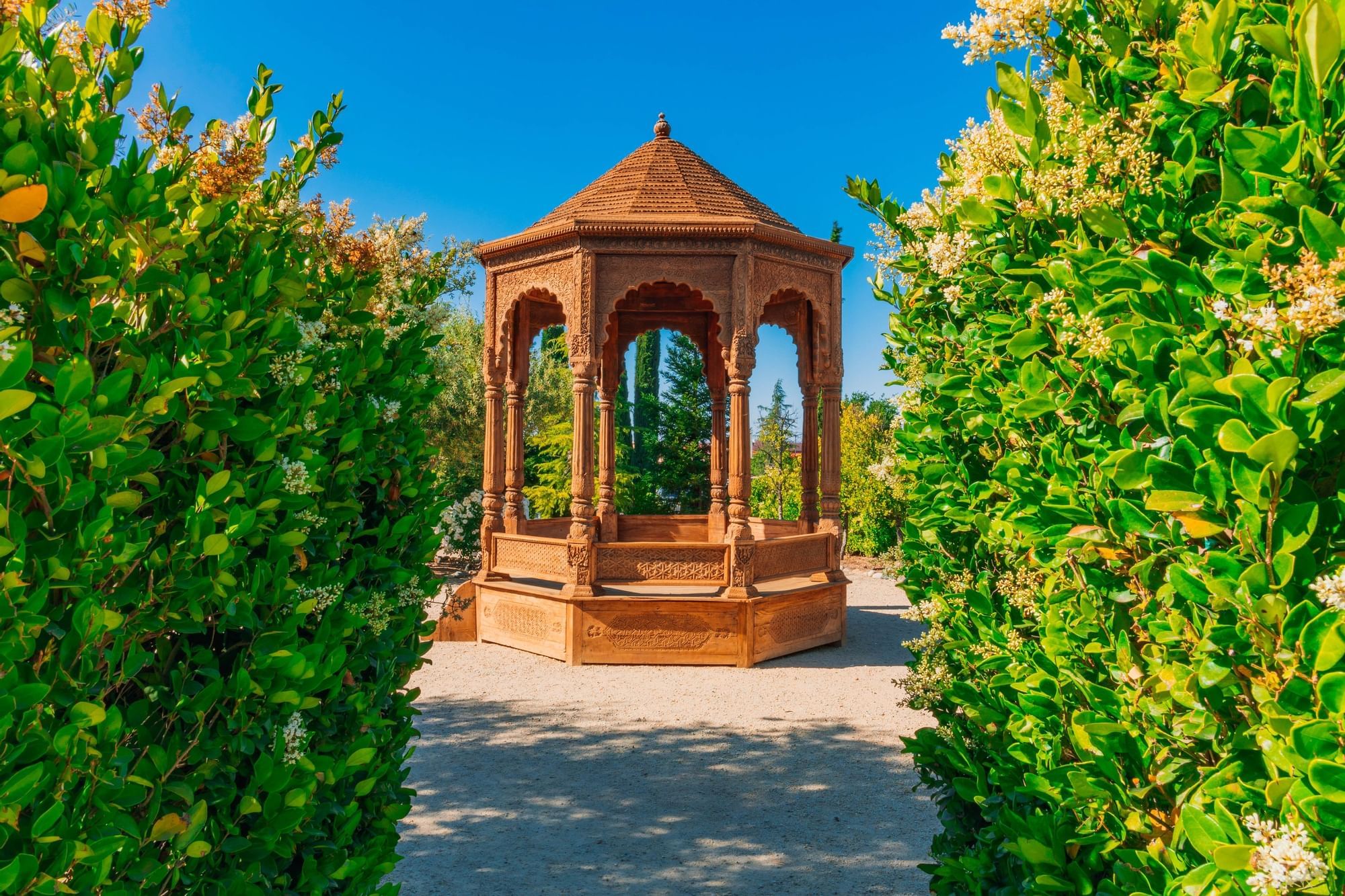 Wooden gazebo with intricate details in a garden