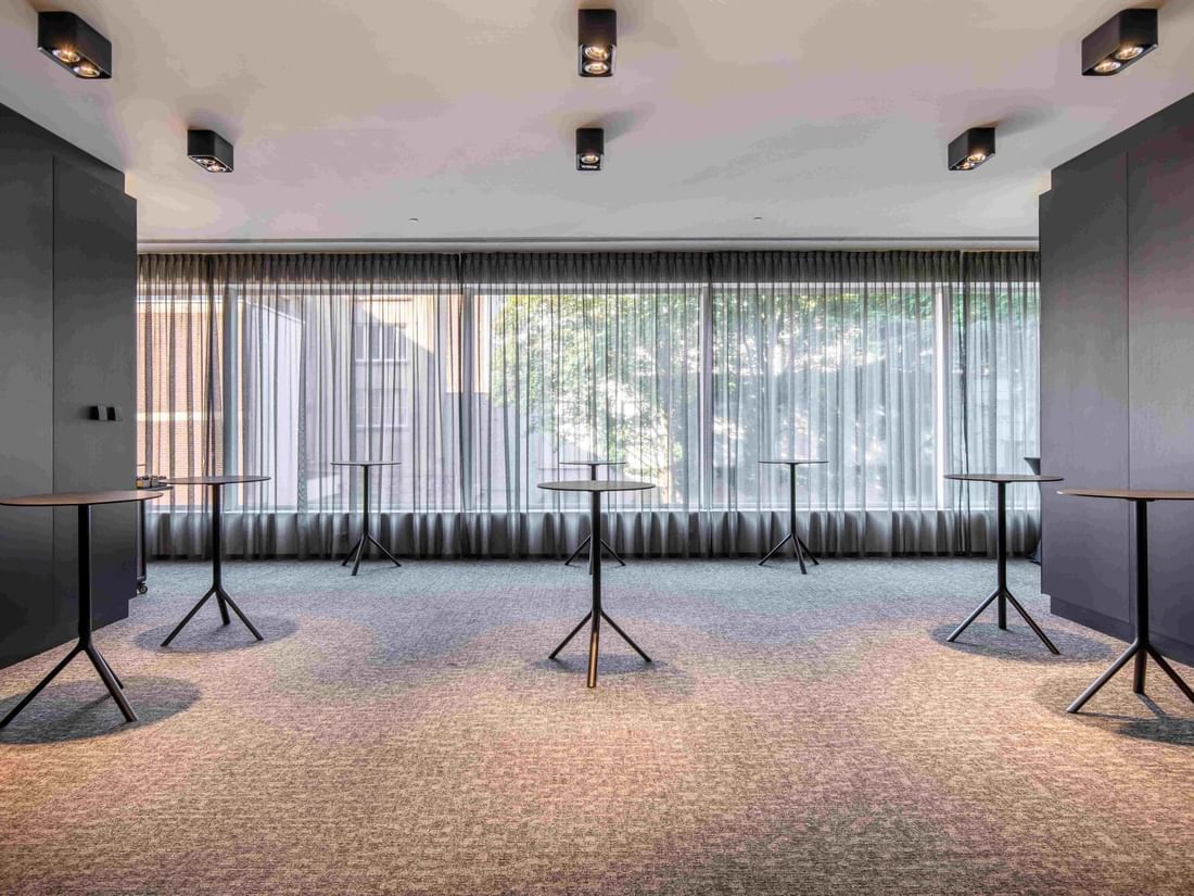 Park Ballroom with standing tables, large windows, and sheer curtains at The Hotel Brussels