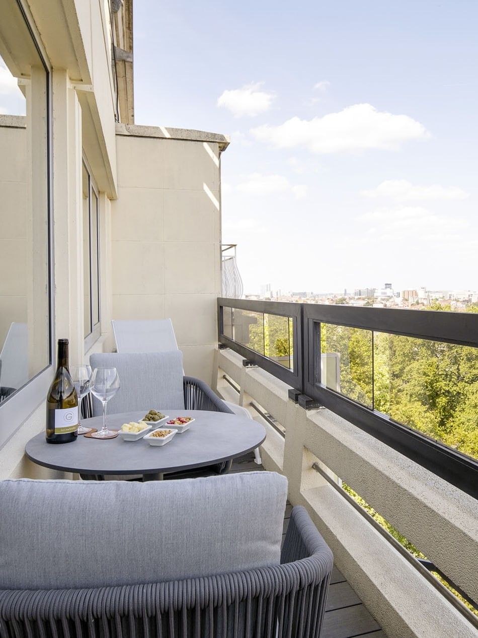 Balkon met uitzicht op de stad en een tafel met wijn en hapjes in Hotel Barsey by Warwick.