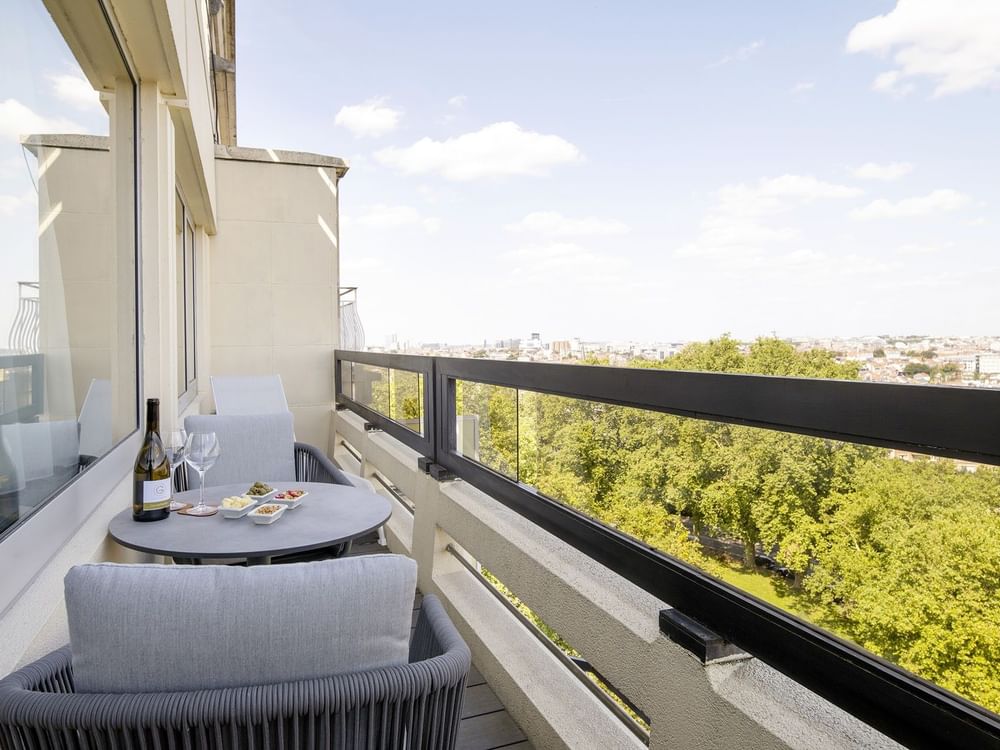 Balkon met uitzicht op de stad en een tafel met wijn en hapjes in Hotel Barsey by Warwick.