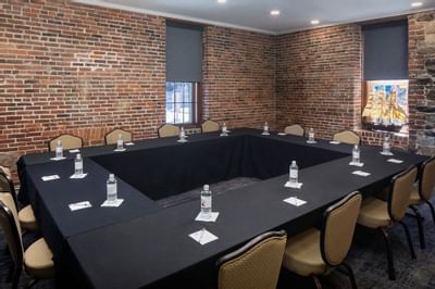U-shaped table set-up with projector screen in Savannah Meeting Spaces at River Street Inn