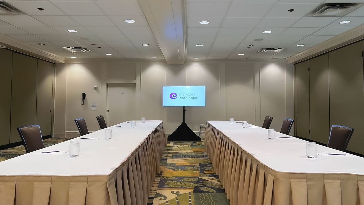 Two long boardroom tables with presentation screen