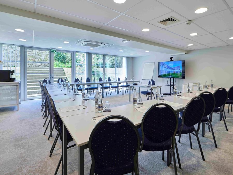 Salle de réunion moderne avec chaises et bureaux à Hôtel La Marébaudière.