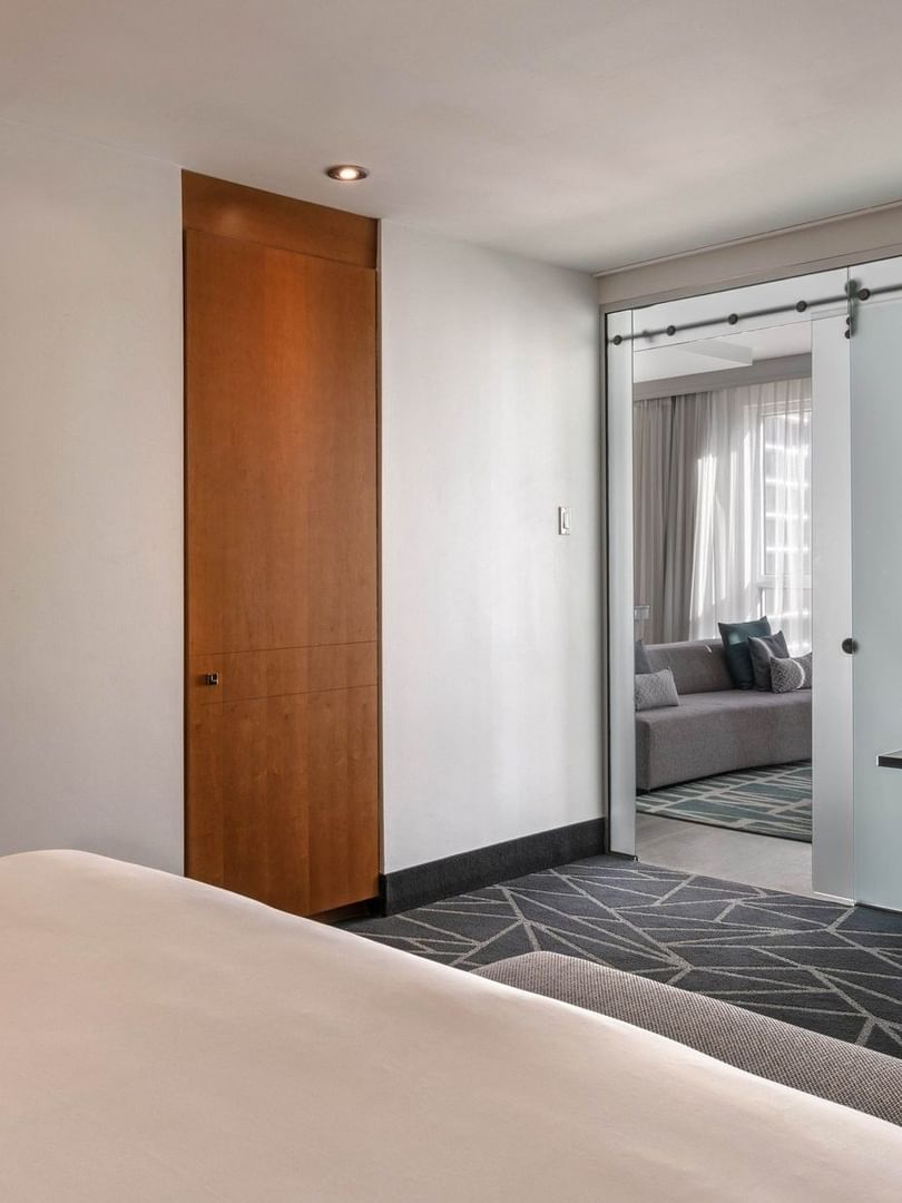 Bed with a work desk near doorway to the separate living area in Penthouse Crescent at Warwick Le Crystal Montreal
