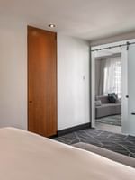 Bed with a work desk near doorway to the separate living area in Penthouse Crescent at Warwick Le Crystal Montreal