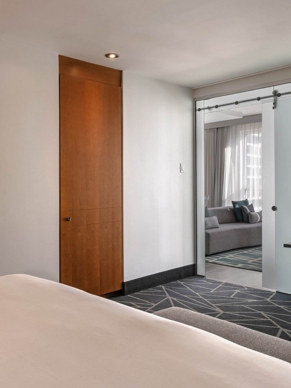 Chambre « Penthouse Crescent » avec lit, bureau et coin salon séparé au Warwick Le Crystal - Montréal.